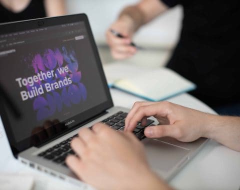 Creative digital branding and marketing on laptop screen at 52 Degrees North office.